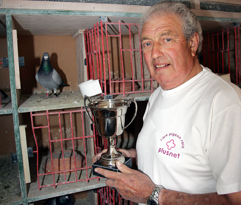 Local champion pigeon fancier, John Redfern, awards trophy to winning bird of Plusnet's fibre optic broadband pigeon race.